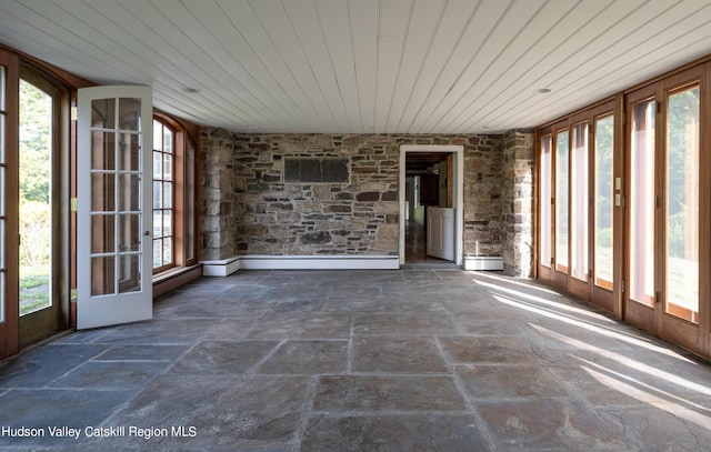 unfurnished sunroom with baseboard heating, wooden ceiling, and a healthy amount of sunlight