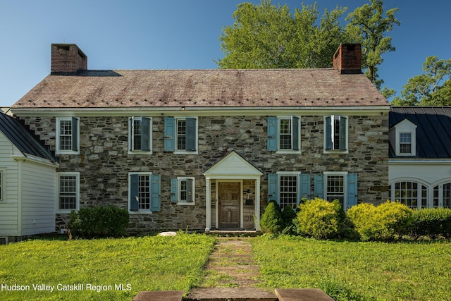 colonial home featuring a front lawn