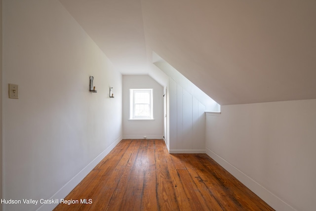 bonus room featuring dark wood-type flooring and vaulted ceiling