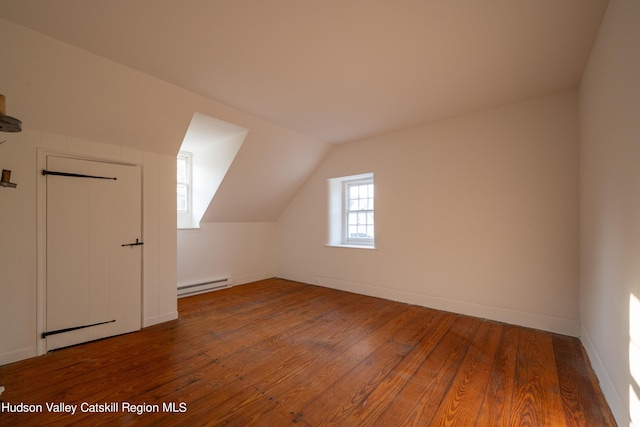 bonus room with wood-type flooring, vaulted ceiling, and a baseboard heating unit