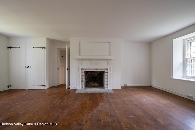 unfurnished living room featuring hardwood / wood-style floors and a tile fireplace