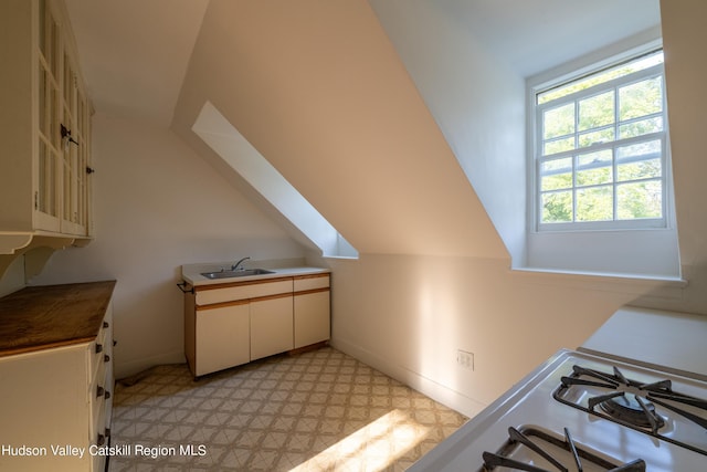 interior space featuring lofted ceiling and sink