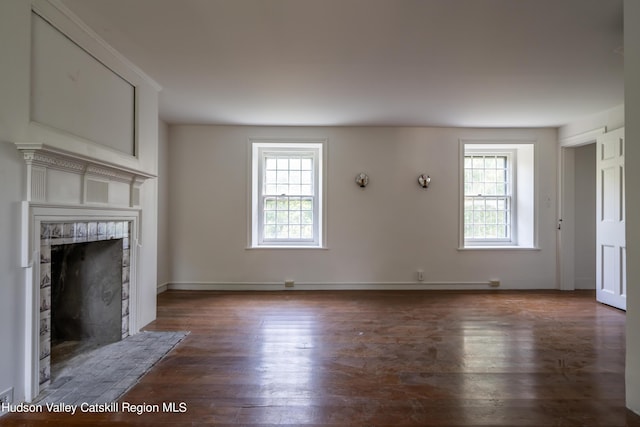 unfurnished living room with a healthy amount of sunlight and dark wood-type flooring