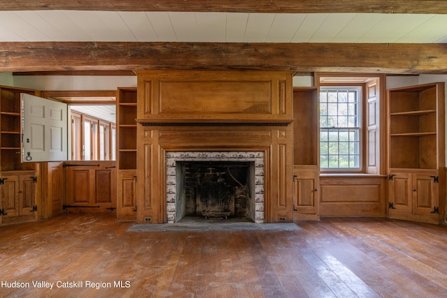 unfurnished living room with wood walls, beamed ceiling, light hardwood / wood-style floors, and wooden ceiling