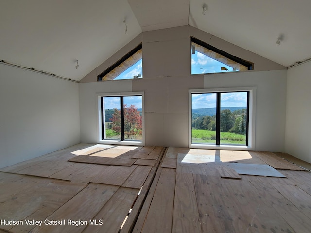 unfurnished room featuring high vaulted ceiling