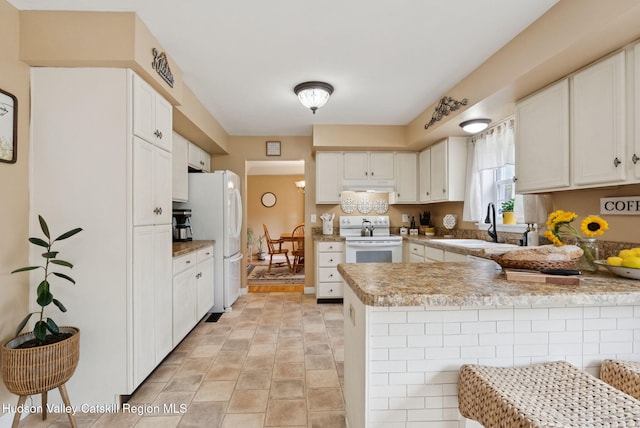 20 Cedar Ridge Rd, Stone Ridge, NY 12484 - kitchen featuring white appliances, a peninsula, under cabinet range hood, white cabinetry, and light countertops