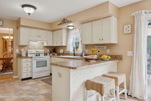 20 Cedar Ridge Rd, Stone Ridge, NY 12484 - kitchen with white range with electric cooktop, under cabinet range hood, a peninsula, white cabinets, and a kitchen bar