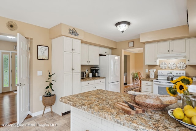 20 Cedar Ridge Rd, Stone Ridge, NY 12484 - kitchen with white appliances, under cabinet range hood, white cabinetry, and light stone counters