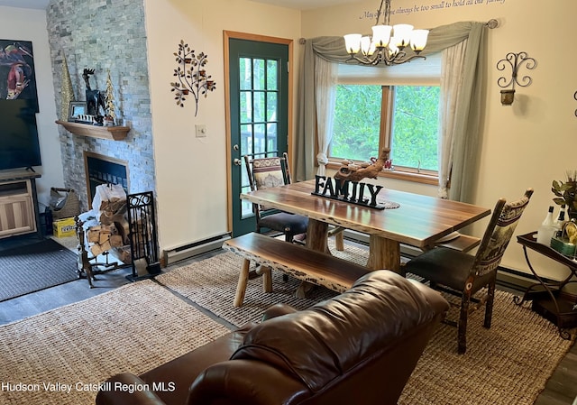82 Liftside Dr Unit A13, Hunter, NY 12442 - dining area featuring wood finished floors, a chandelier, a baseboard heating unit, and a stone fireplace