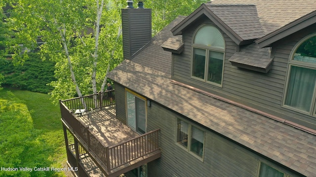 82 Liftside Dr Unit A13, Hunter, NY 12442 - view of property exterior featuring a shingled roof, a wooden deck, and a chimney