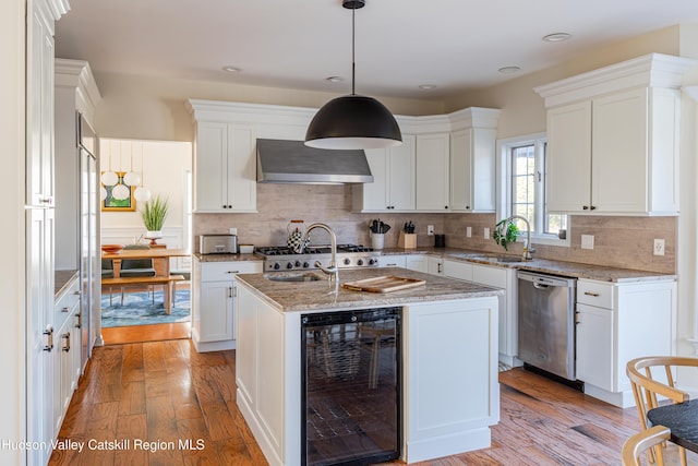 kitchen featuring light wood-type flooring, wall chimney exhaust hood, sink, dishwasher, and wine cooler