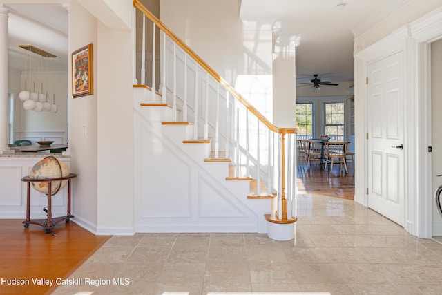 stairs featuring wood-type flooring and ceiling fan