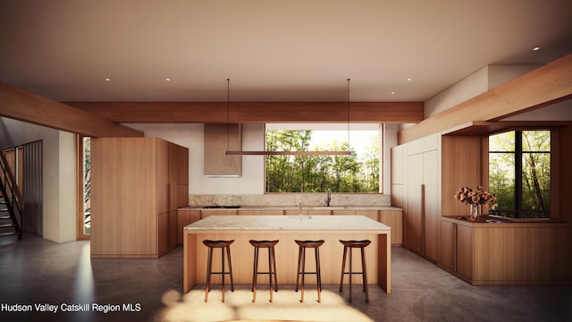 kitchen featuring a kitchen breakfast bar, a kitchen island, sink, and hanging light fixtures