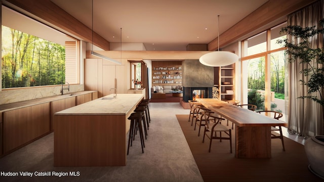 carpeted dining space with a multi sided fireplace, a wealth of natural light, and sink