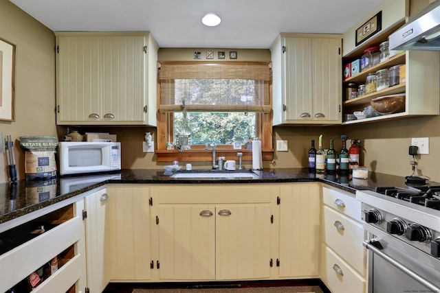 kitchen with cream cabinets, dark stone counters, and sink