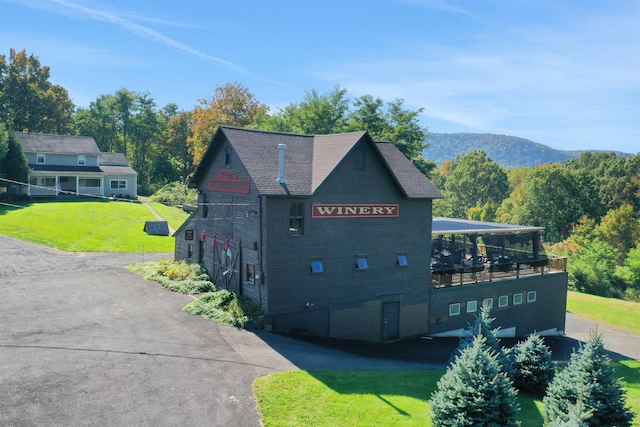 view of side of home with a lawn and a mountain view