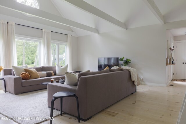 living room featuring vaulted ceiling with beams and light wood-type flooring