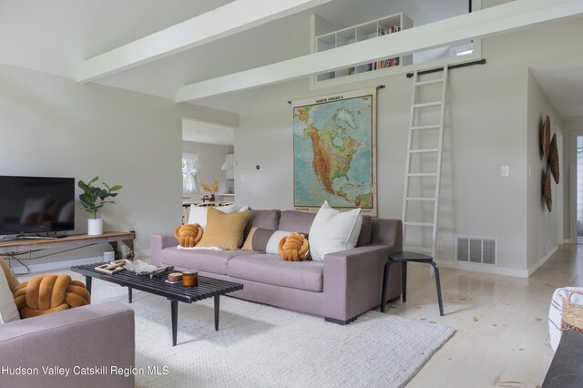 living room with beam ceiling and light hardwood / wood-style floors