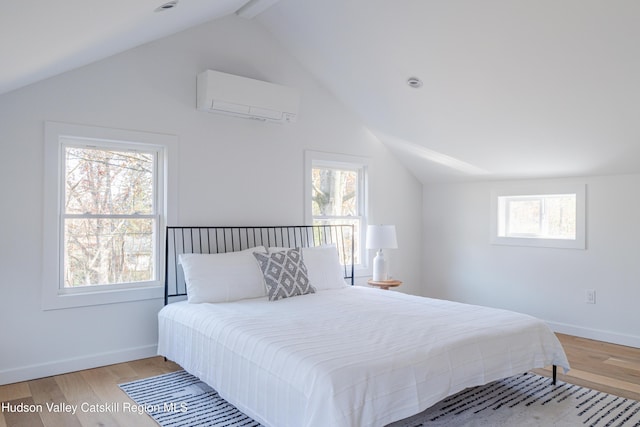 bedroom featuring an AC wall unit, multiple windows, light hardwood / wood-style flooring, and lofted ceiling