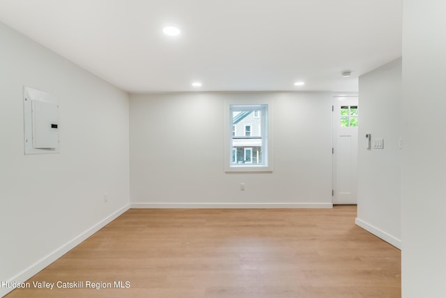 empty room featuring electric panel and light hardwood / wood-style floors