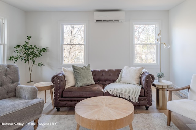 living room with a wall mounted air conditioner and light wood-type flooring