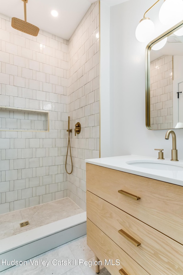 bathroom featuring tile patterned floors, vanity, and tiled shower