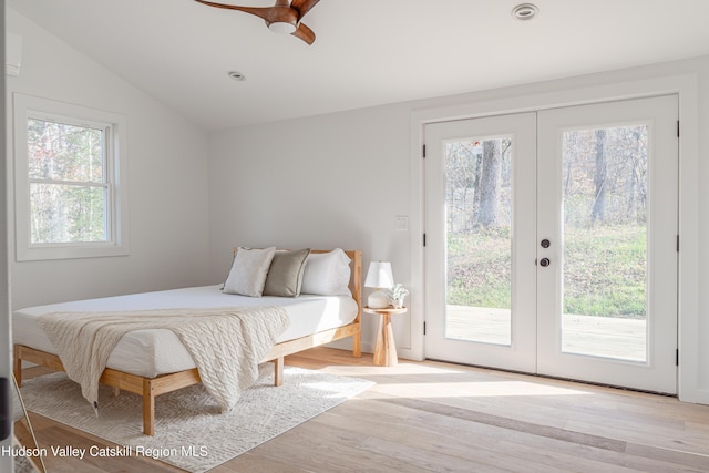 bedroom featuring lofted ceiling, french doors, light hardwood / wood-style flooring, ceiling fan, and access to exterior