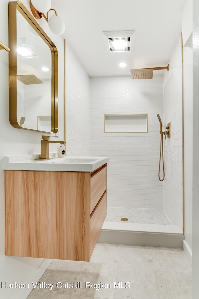 bathroom with vanity and tiled shower