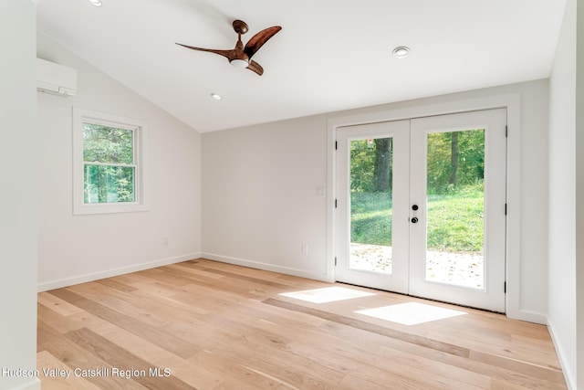 entryway with lofted ceiling, french doors, light hardwood / wood-style floors, and a wall mounted air conditioner