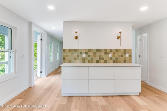 kitchen featuring light hardwood / wood-style flooring, white cabinetry, and a wealth of natural light