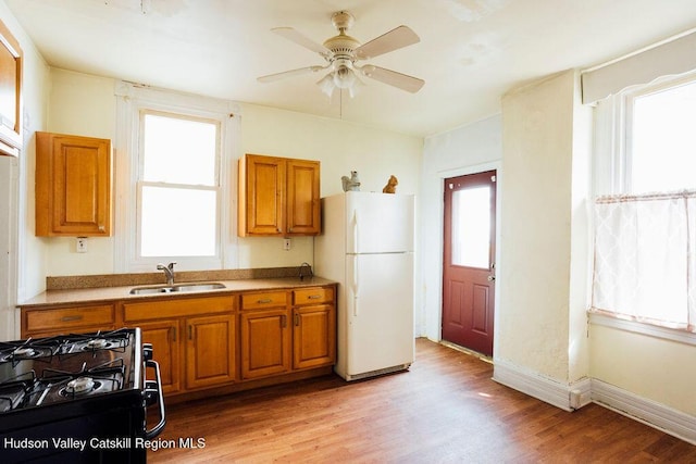 604 Columbia St, Hudson, NY 12534 - kitchen featuring a sink, freestanding refrigerator, black gas range oven, and brown cabinets