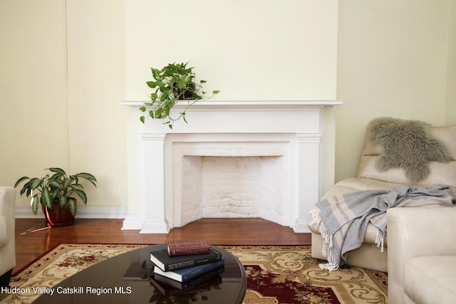 604 Columbia St, Hudson, NY 12534 - living area with wood finished floors, baseboards, and a fireplace
