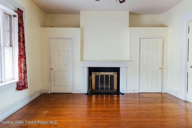604 Columbia St, Hudson, NY 12534 - unfurnished living room featuring wood finished floors, a fireplace with flush hearth, ceiling fan, and baseboards