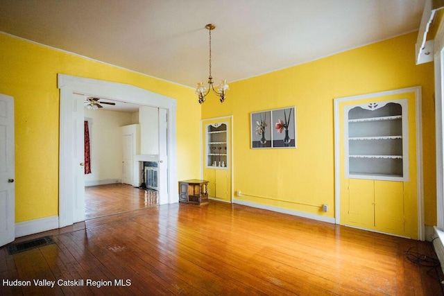 604 Columbia St, Hudson, NY 12534 - unfurnished dining area with hardwood / wood-style flooring, a fireplace, baseboards, a chandelier, and built in shelves
