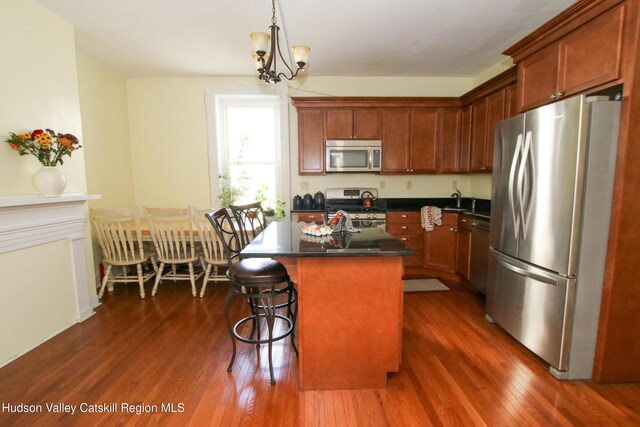 604 Columbia St, Hudson, NY 12534 - kitchen with stainless steel appliances, dark wood finished floors, dark countertops, a kitchen breakfast bar, and a kitchen island