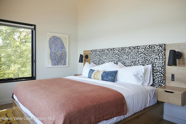 bedroom featuring dark hardwood / wood-style flooring and multiple windows