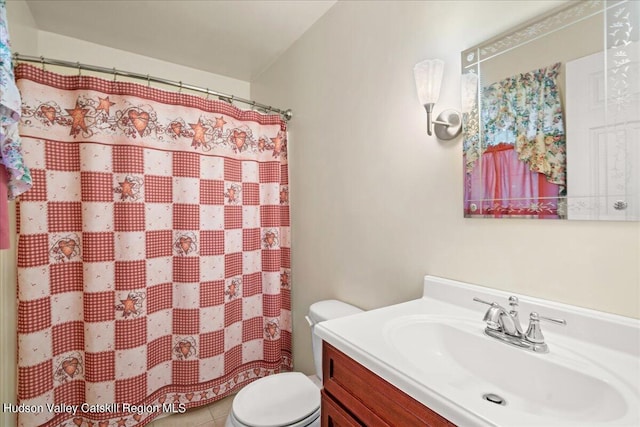 bathroom featuring tile patterned flooring, vanity, toilet, and curtained shower