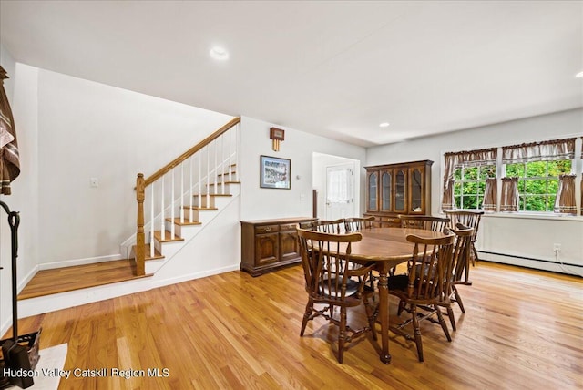 dining area with light hardwood / wood-style floors and a baseboard radiator