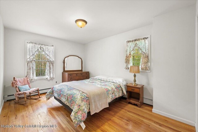 bedroom featuring wood-type flooring and baseboard heating