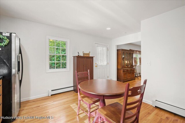 dining area with light wood-type flooring and a baseboard radiator