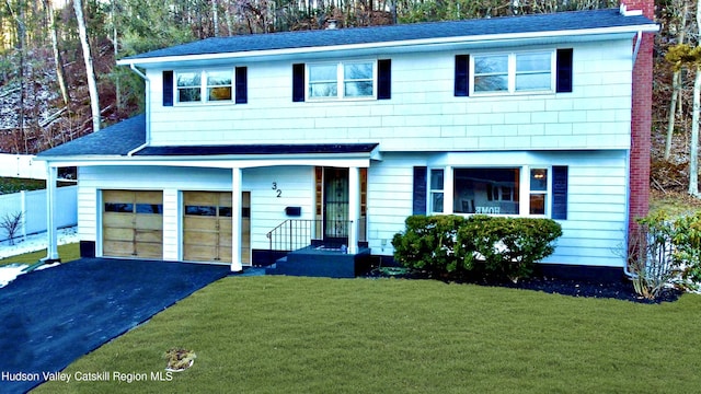 32 Redwood Rd, Saugerties, NY 12477 - view of front facade featuring a chimney, aphalt driveway, a garage, and a front lawn