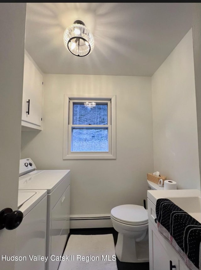 clothes washing area with a baseboard radiator and washer and dryer