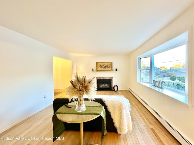 32 Redwood Rd, Saugerties, NY 12477 - living area with a baseboard radiator, a fireplace, baseboards, and light wood-style floors