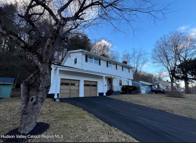 view of front of house featuring a garage and a front lawn