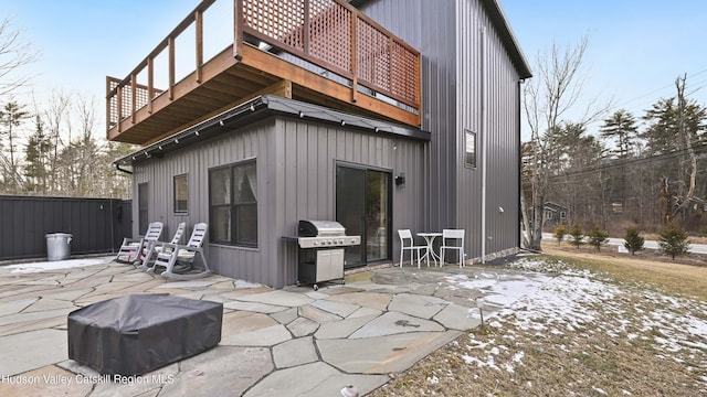 snow covered rear of property with a patio