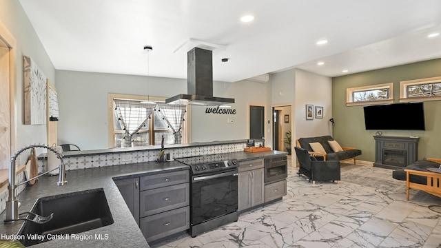 kitchen with decorative light fixtures, sink, island range hood, and stainless steel appliances