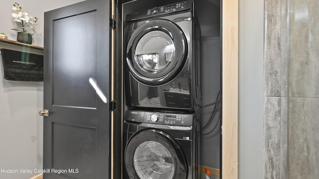 washroom featuring stacked washer and clothes dryer