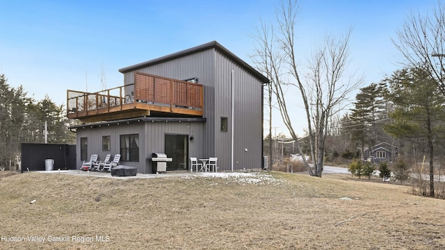 rear view of property with a deck and a patio area