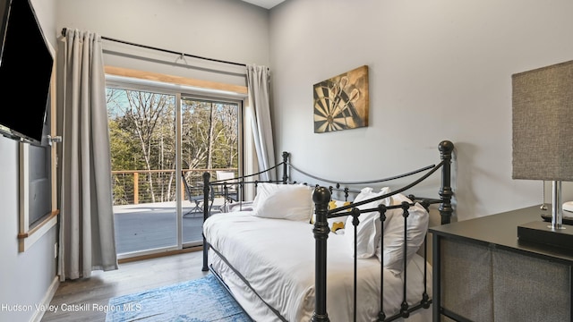 bedroom featuring access to exterior and light hardwood / wood-style flooring