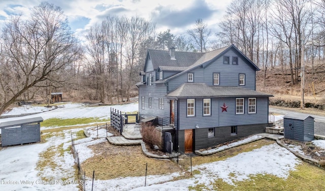 snow covered property featuring a chimney